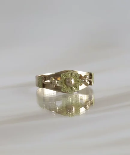 bague ancienne en or rose et jaune surmontée d'une fleur ciselée avec un bouton d'or