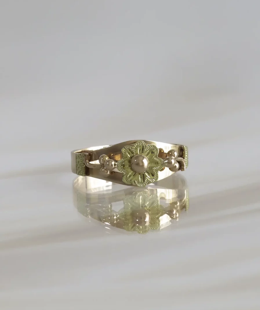 bague ancienne en or rose et jaune surmontée d'une fleur ciselée avec un bouton d'or
