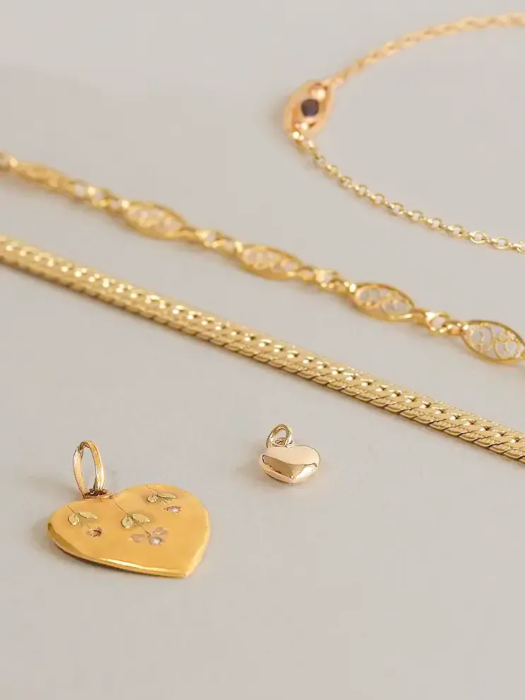 pendentifs et chaînes en or posés sur une table